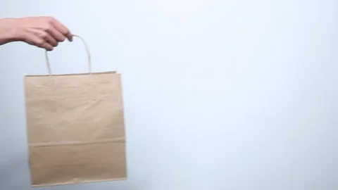Hand passes the eco-friendly paper bag to the other hand.  Stock Footage 119233370
