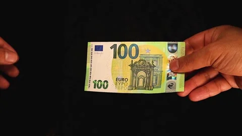 Hand Passing a €100 Euro Note European Currency or Financial Transaction Stock Footage 297746792