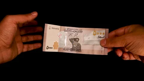 Hand Passing a 5000 Syrian Pound. Currency Exchange or Financial Transaction Stock Footage 297877030