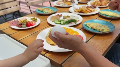 Hand passing boiled egg to child at breakfast Stock Footage 336937573