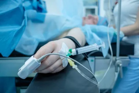 Hand of the patient lying on the operating table. On the finger is a pulse Stock Photos