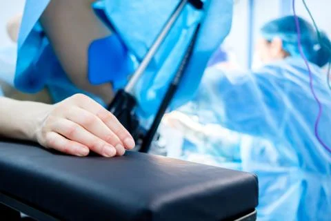 Hand of a patient lying on the operating table. The patient is sleeping under Stock Photos