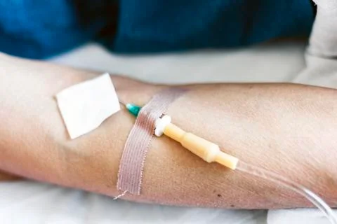Hand of patient in serious condition is given a medicine through a dropper (h Stock Photos
