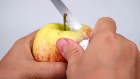 Hand peeling apple with knife close up. Woman peeling a red apple in the kitchen Stock Footage 248585751