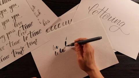 Hand with pen brush is trying to do the lettering exercise and fails Stock Footage 96218909