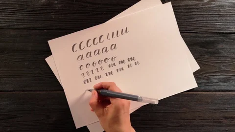 Hand with pen brush is trying to do the lettering exercise and fails Stock Footage 96218996