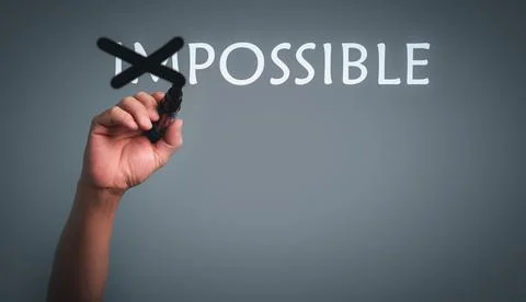 Hand with pen changing the word impossible to possible with cross out im text Stock Photos