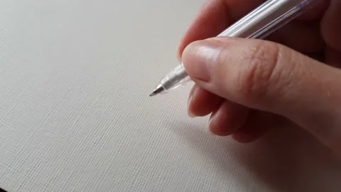 Hand with pen over a blank sheet of textured notebook. Stock Footage 181012216