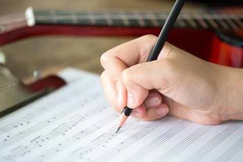 Hand with pencil and music sheet Stock Photos