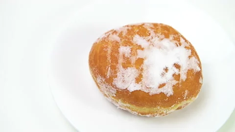Hand person placing one single powdered sugar donut on white plate macro Stock Footage 169348747