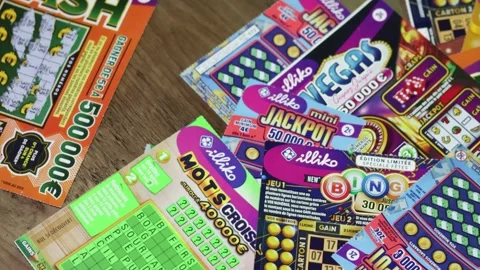 Hand of a person scratching scratch card tickets from Française des Jeux Stock Footage 296810363