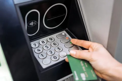 Hand of a person using an ATM machine, entering a PIN code on the keypad, w.. 写真素材