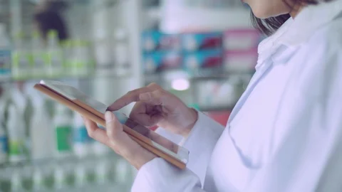 Hand of pharmacist using tablet computer to finding drug information Stock Footage 113976989