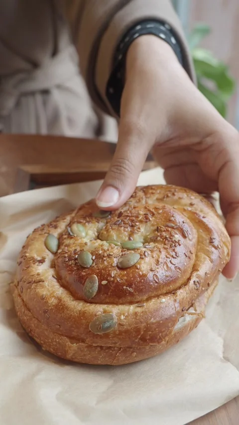 Hand pick a fresh baked bread on a wooden table in a cafe Stock Footage 343354667