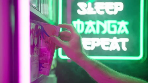 Hand pick a manga comic from shelf with futuristic neon sign in background 4K Stock Footage 320240426
