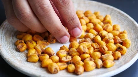 Hand pick peanuts on plate on table Stock Footage 241889533