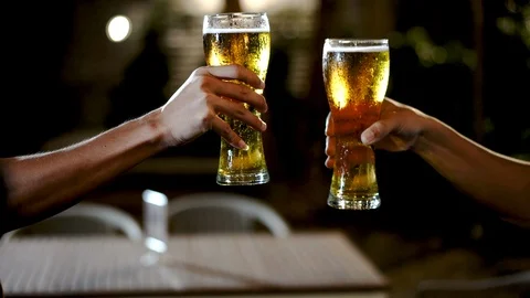 The hand that picked up the glass of beer collided before drinking. Stock Footage 110859342