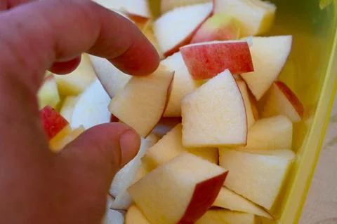 Hand picking apple cube close-up Fotos Stock