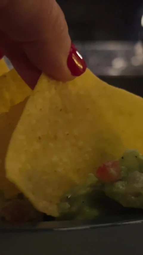 Hand picking up avocado salsa and guacamole dip sauces, nacho chips on stone Stock Footage 293253917