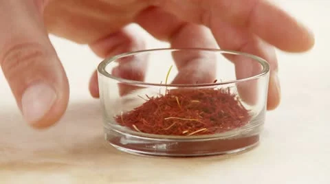 Hand picking up bowl of saffron threads Stock Footage 24663511