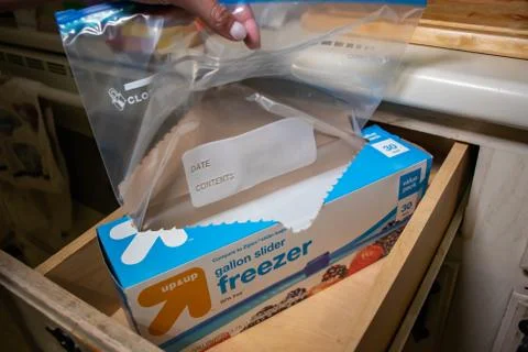 Hand picking up a box of zip lock bags Stock Photos