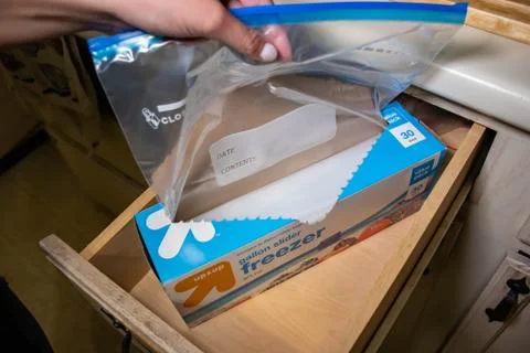 Hand picking up a box of zip lock bags Stock Photos