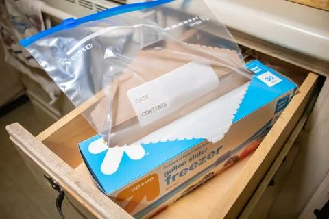 Hand picking up a box of zip lock bags Stock Photos