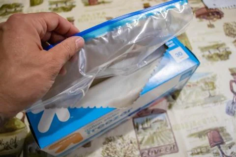 Hand picking up a box of zip lock bags Stock Photos