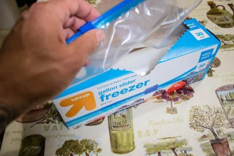 Hand picking up a box of zip lock bags Foto stock