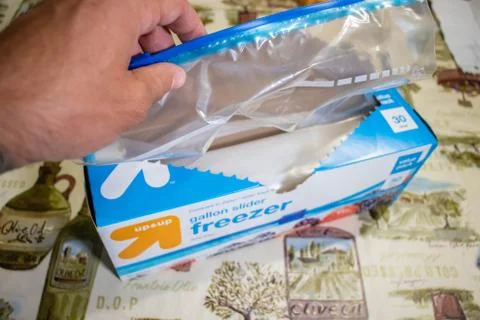 Hand picking up a box of zip lock bags Foto stock