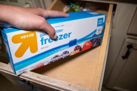 Hand picking up a box of zip lock bags Stock Photos