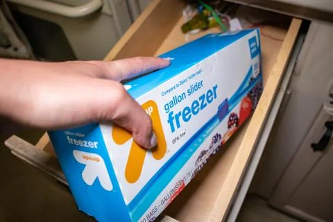 Hand picking up a box of zip lock bags Stock Photos