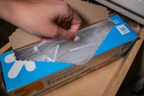 Hand picking up a box of zip lock bags Stock Photos