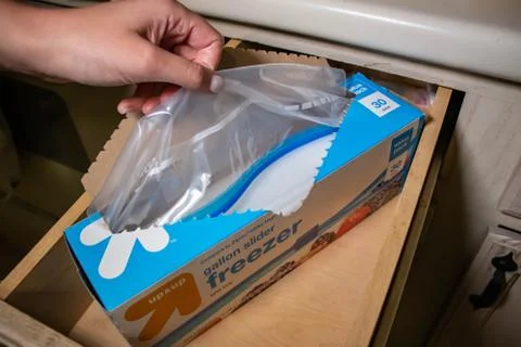 Hand picking up a box of zip lock bags Stock Photos