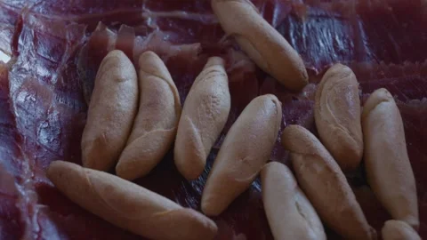 Hand picking up breadsticks from spanish serrano ham tapas platter Stock Footage 337221407