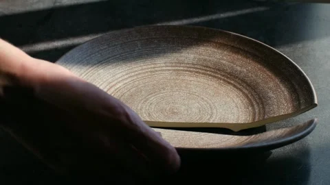 Hand picking up broken ceramic plate from table Video stock 337892638