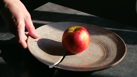 Hand picking up broken plate piece near apple Stock Footage 337892637