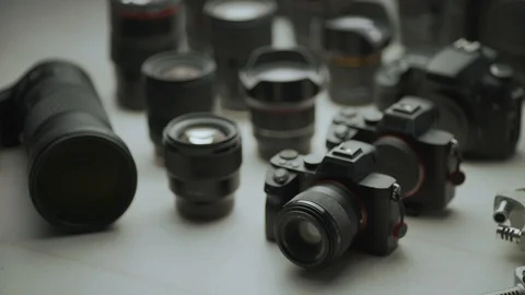 A hand picking up the camera between another camera and lens. Video stock 128406429