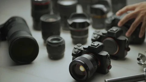 A hand picking up the camera between another camera and lens. tools of trade Video stock 128406521