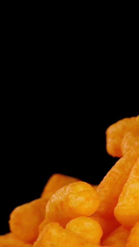 Hand Picking Up Cheese Puffs Snack Against Black Background Stock Footage 325154864