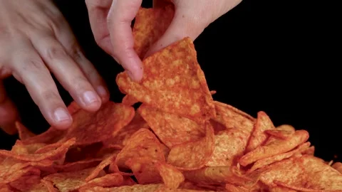 Hand Picking Crispy Nacho Chips from Pile on Black Background Stock Footage 319512791