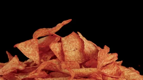 Hand Picking Crispy Nacho Chips From Pile on Black Background Stockbeeldmateriaal 319522253