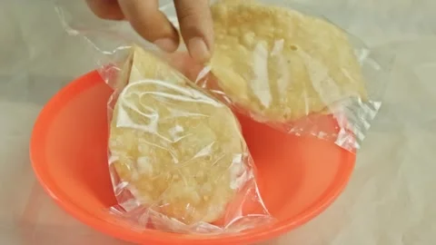 Hand picking up crispy sweet crackers in transparent plastic packaging on o.. Stock Footage 324819882