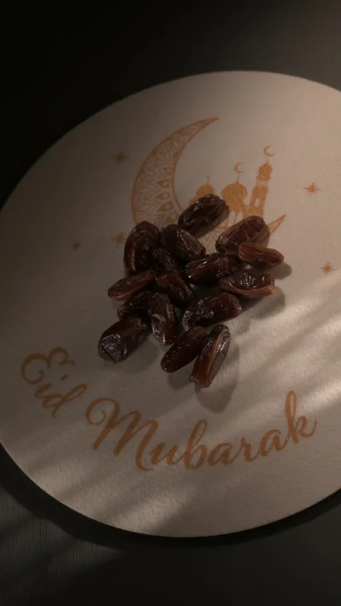 Hand picking a date from an Eid Mubarak plate during Ramadan Stock Footage 328337142