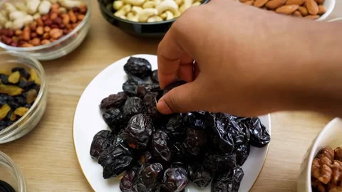 Hand Picking Dates from a Plate of Snacks Stock Footage 318578640