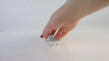 Hand picking up dice to throw on a white background Stock Footage 85363940