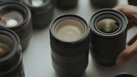 A hand picking down the lens of the camera between another lens. Video stock 128407469