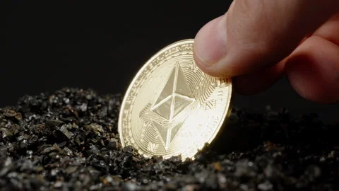 A Hand Picking Up an Ethereum Coin Embedded in Dark Rocks. The Smooth Surface Stock Footage 296473769