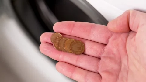 Hand picking up found coins from washing machine drum Stock Footage 264271692