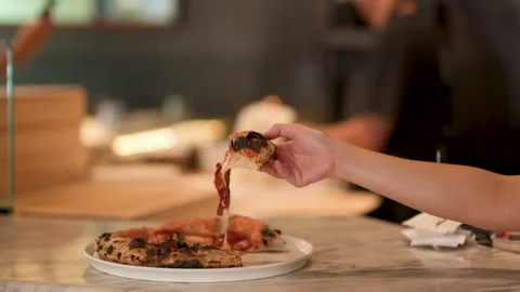 Hand Picking Up Fresh Pizza Slice with Melting Cheese Stock Footage 340865843